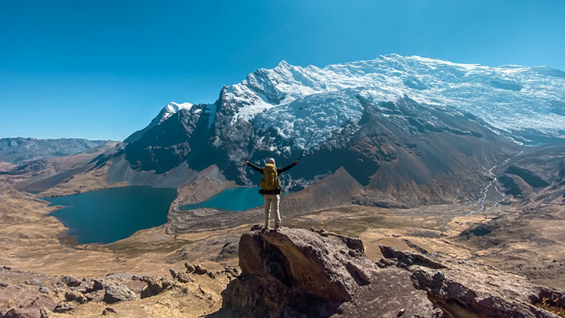Tourist with his camping gear viewing the sacred mountain of Ausangate